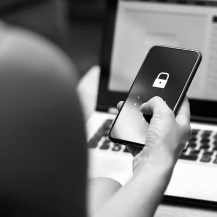 Personne tenant un téléphone verrouillé avec un cadena sur l'écran