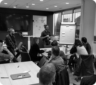 Groupe de travail dans une salle en train d'écouter l'intervenant expert
