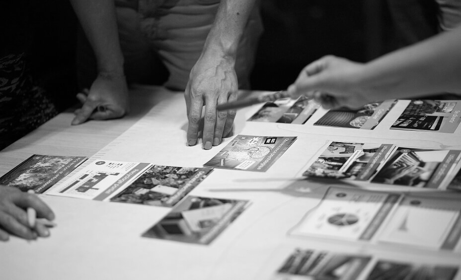 Mains visible autour d'une table lors d'un atelier de la Fresque du Numérique