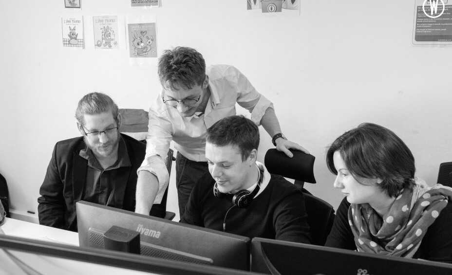 Collaborateurs devant un écran d'ordianteur en train de partager des informations